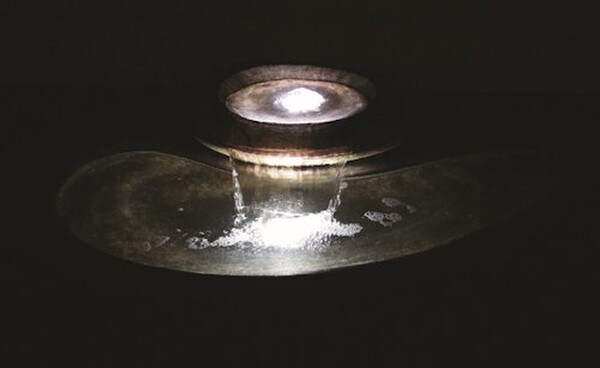 The River Stone Fountain boasts a swirling and swooping design nighttime